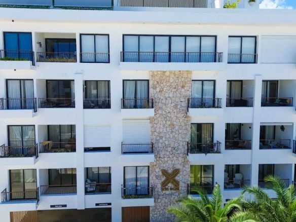 Modern 2-bedroom apartment at Blue Palms in Ciudad Las Canas, Cap Cana, with a private balcony and lush garden views.
